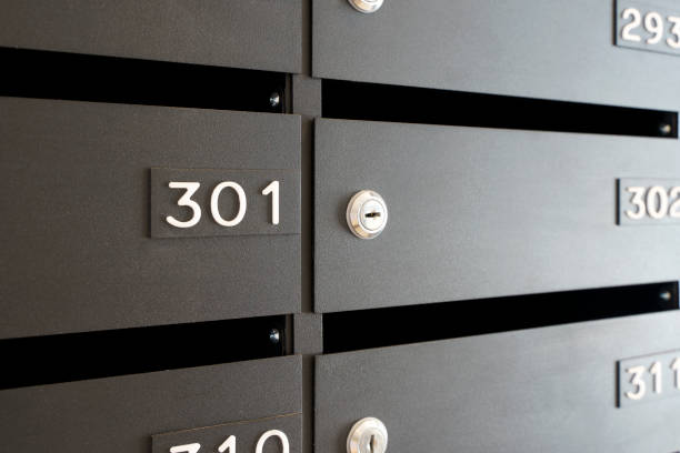 istock Mailboxes for letters and correspondence. Modern black mailboxes with numbers in the lobby of a residential or office building 1351075523