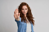 Young woman with red hair showing stop sign