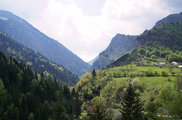 Farm houses, seen at right, overlook the Rugova Mountain Gorge in the northwest mountains of Kosovo. The remains of a house destroyed during the recent Balkan wars can be seen at the lower center of the photo.