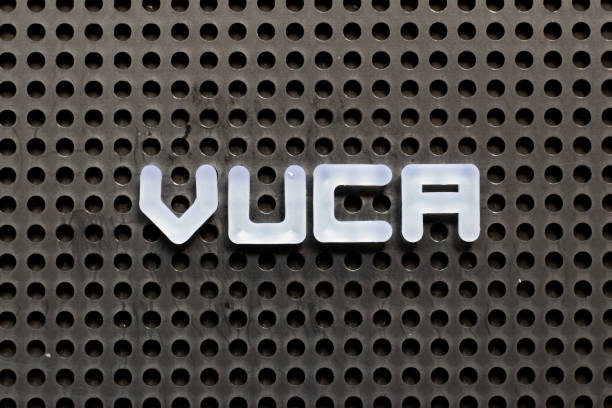 White color letter in word VUCA (abbreviation of Volatility, uncertainty, complexity and ambiguity) on black pegboard background