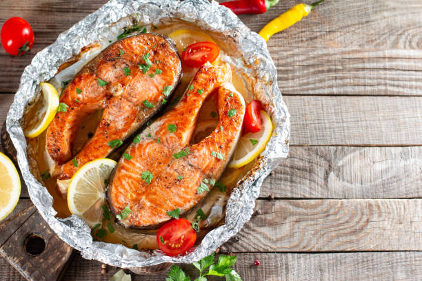istock Fried salmon steak with lemon, vegetables, herbs and spices on table. Top view. Free copy space. 1351077246