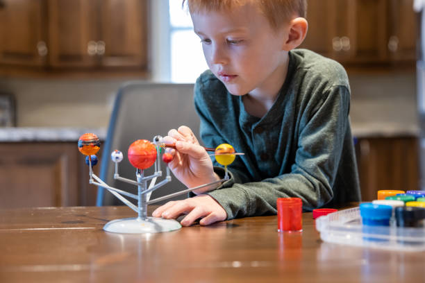 istock Cute redhead boy creating his homemade solar system and painting planets 1351077470