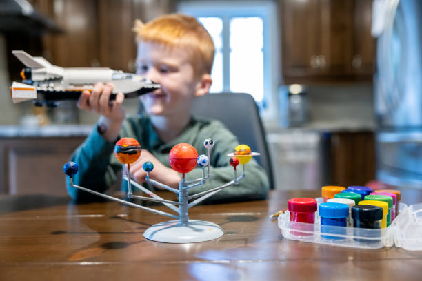 istock Cute redhead boy playing with homemade solar system and rocket or spaceship 1351077501