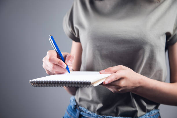 istock woman holding pen with notepad 1351077740