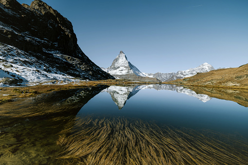 the Matterhorn Mountain in the swiss alps reflecting in mountain lake Riffelsee in the morning hour