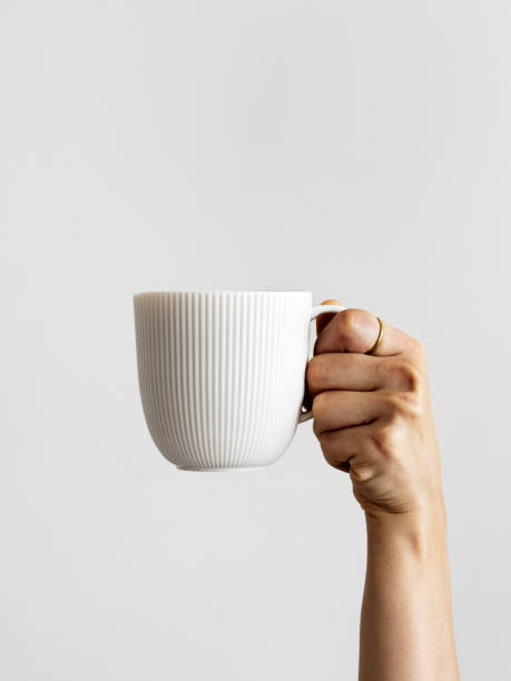 Woman hands raised arm up holding coffee cup, Hands holding cup of Coffee, Fresh cup of coffee, Arm raised up holding coffee cup, stock photo