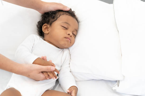 istock black African American baby sleeping on a white mattress. 1351079472