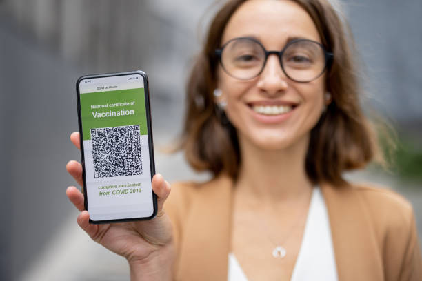 istock Woman show phone with Coronavirus Vaccination app 1351079548