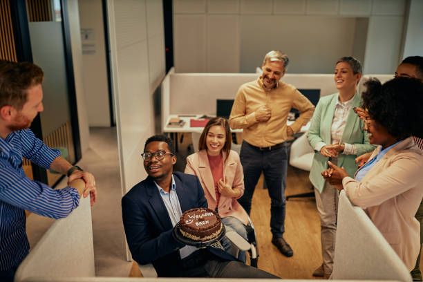 istock Handsome black businessman holding Welcome back-cake in office 1351081644
