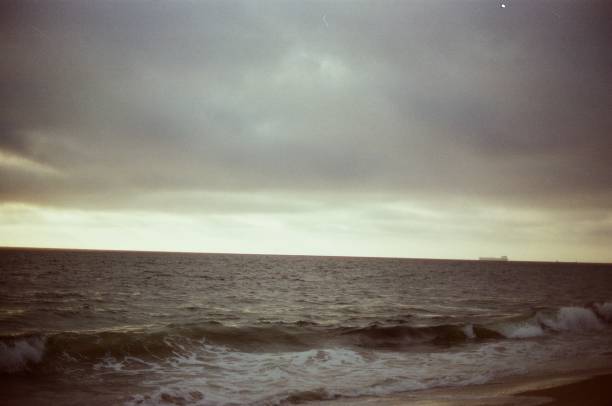 istock Moody Beach with ship on horizon 1351083997