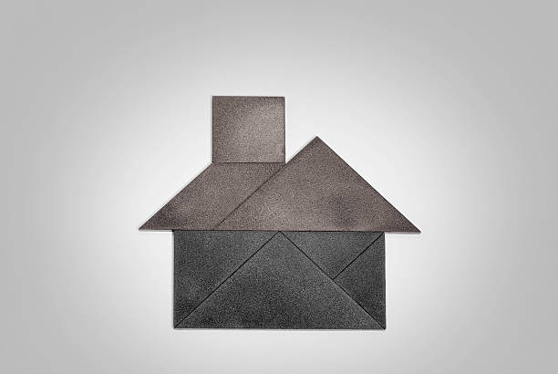 Tangram house made by textured black pieces. Colored red roof