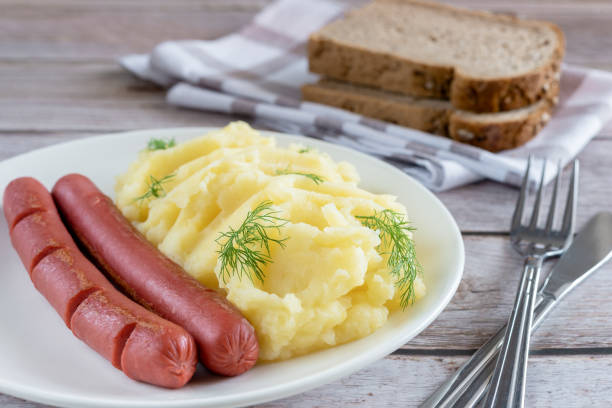 mashed potatoes, garnished with dill and sausages on an old wooden background. - sausage food mash grilled imagens e fotografias de stock
