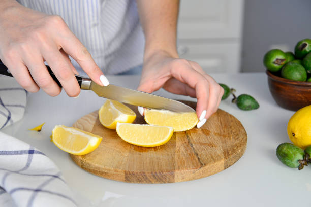 istock woman hands is cutting lemon on wooden. 1351084496