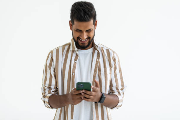 istock Portrait young indian businessman using cellphone on white background 1351085463
