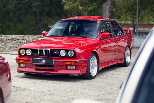 Reocin, Cantabria, Spain - October 2, 2021: Exhibition of classic vehicles. The first BMW M3 was based on the E30 3 Series and It was presented to the public at the 1985 Frankfurt Motor Show. In the photo an example in red