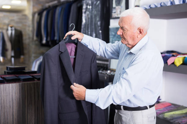 istock Senior man customer choosing jacket in clothes shop 1351085765