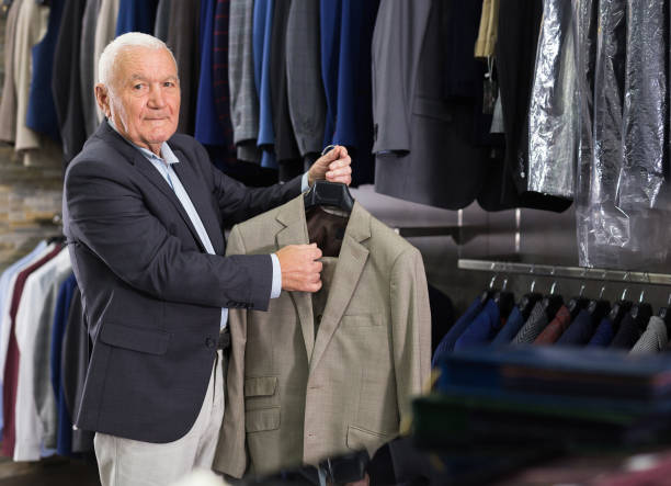 istock Senior man customer choosing jacket in clothes shop 1351085787