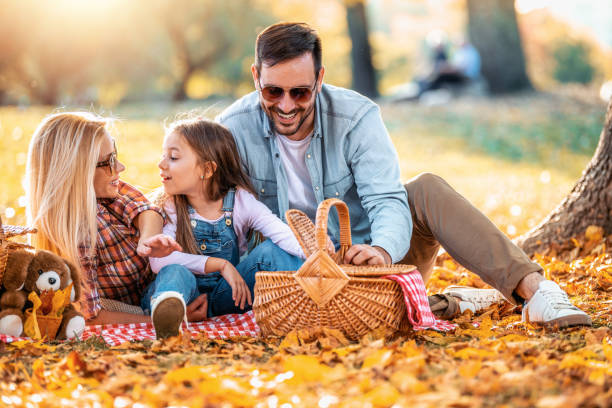 Joyful family picnicking in the park stock photo