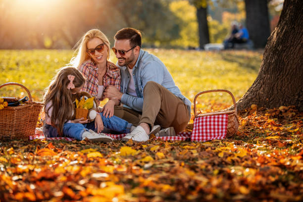 Joyful family picnicking in the park stock photo