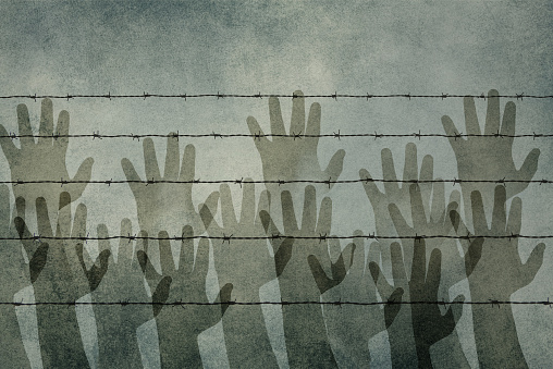 Silhouettes of hands behind a barbed wire, refugee camp, border, illegal immegration issue, prison fence, dark color