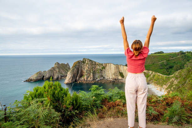 turista emocionado levantando brazos en una hermosa costa - playa del silencio asturias fotografías e imágenes de stock