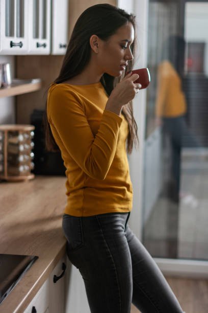istock Woman drinking coffee in the kitchen 1351092240