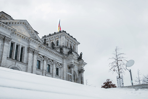 low angle view on snowy Berlin Reichstag in winter under pale sky
