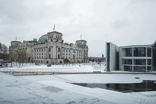 view on snowy government district with Berlin Reichstag under pale winter sky