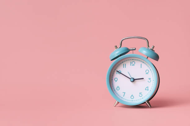 istock Alarm clock. Classic watch on a pink background. 1351092775