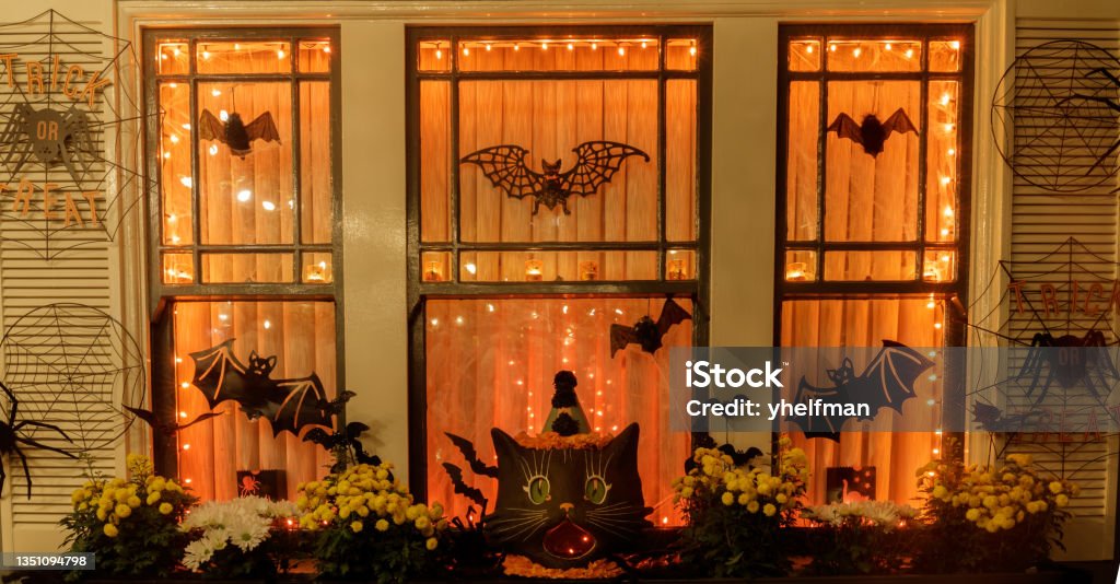 Halloween decorations hanging outside residential building window at night of trick or trick Halloween Stock Photo