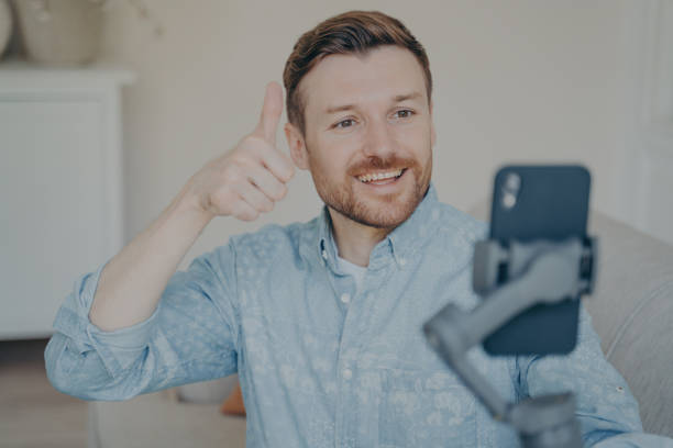 istock Young man showing thumbs up gesture while video chatting on phone 1351097494