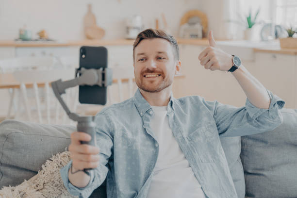 istock Young man in video call expressing his satisfaction by showing thumbs up 1351097501