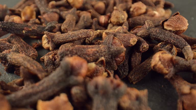 Dried buds of carnation flowers on a dark background. Spices for cooking. Dried cloves with a strong aroma and burning taste.