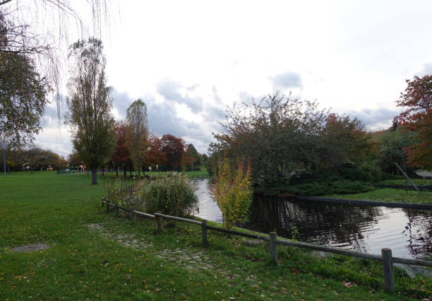 istock Pond in a public park lined with various trees  Autumn season  Threatening sky 1351099951