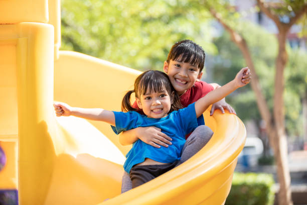 Asian Siblings playing at the playground and smiled and laughed happy stock photo