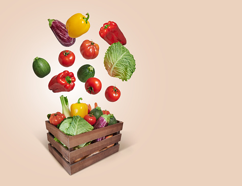 Vegetables flying in wooden box with copy space
