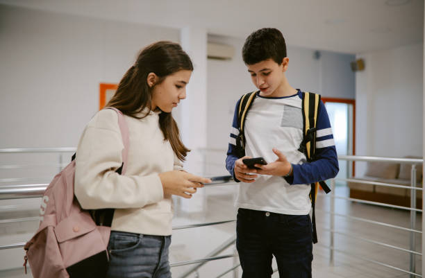 istock High school kids checking their smartphones after classes 1351101662
