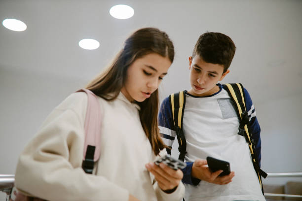 istock High school kids checking their smartphones after classes 1351101726