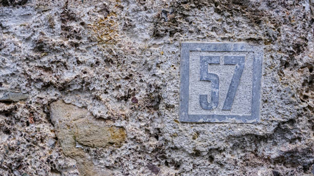 Ceramic house number on wall. number fifty-seven. 57