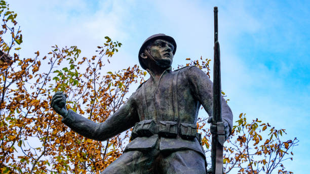istock statue of soldier first world war throwing hand grenade. trees and sky on the bottom. Castelsaraceno, Basilicata, Italy. 1351102068