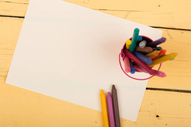 istock colored crayons and blank page on the wooden table 1351103527