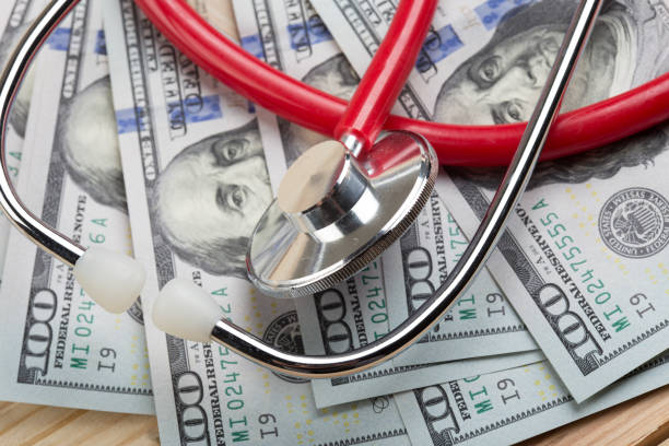 médecins stéthoscope médical sur l’argent contexte soins de santé concept coûteux - dépense photos et images de collection