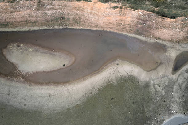 istock Dirty bottom of a dried-up lake. Ecological problems 1351107131