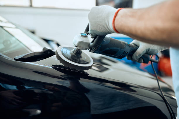 istock Close-up of worker polishing car while working at service workshop. 1351107555