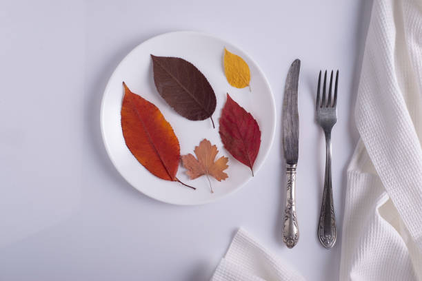 istock creative autumn concept canteen table setting autumn leaves on a plate on a white background 1351108066