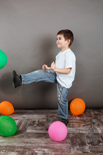 Happy little boy playing with colorful balloons and having fun