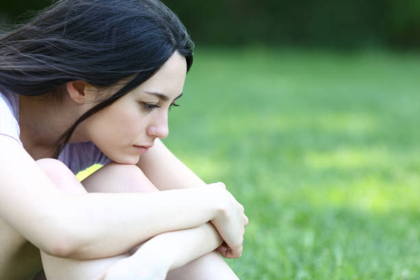 istock Sad asian woman complaining alone in a park 1351111920
