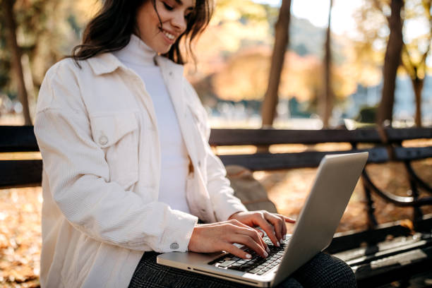 istock Working outdoor sitting on a park bench in fall season 1351112865