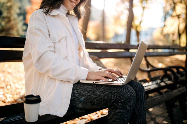 istock Working outdoor sitting on a park bench in fall season 1351112886
