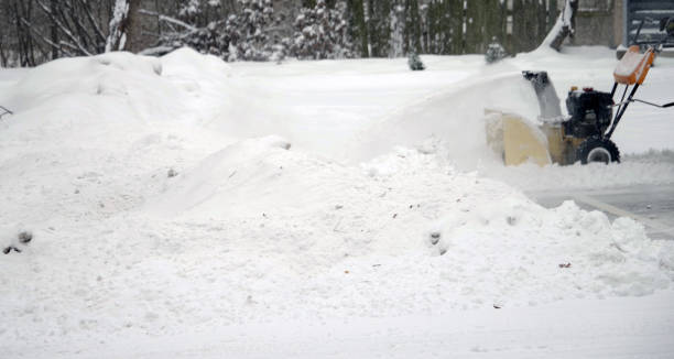 istock Gas snow blower throws out snow with asphalted parking. 1351112968